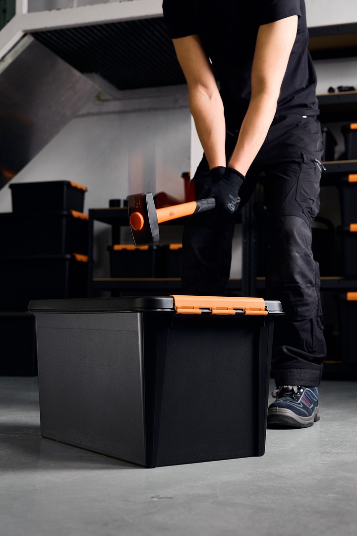 Eine Person schlägt mit einem Hammer auf eine SmartStore Pro-Aufbewahrungsbox.